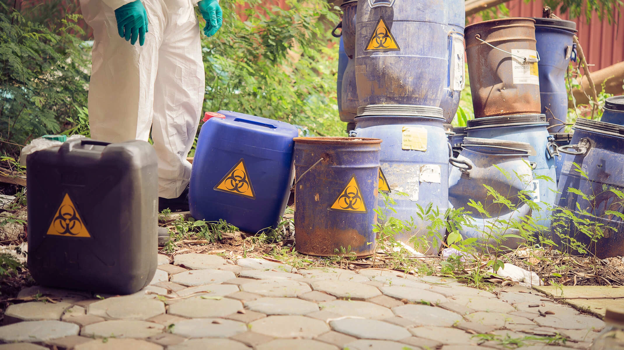 Tas de bidons contenant des déchets dangereux, laissés dans la nature